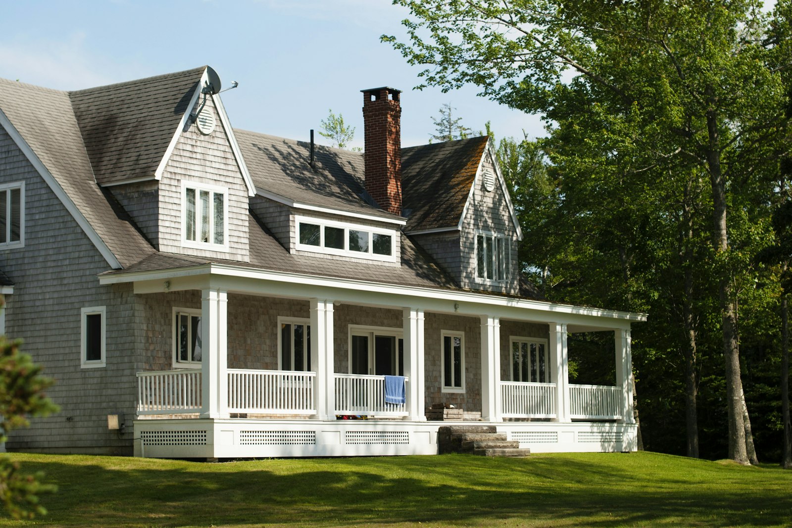 Traditional white-and-brown two-story home framed by mature shade trees, representing Wilmington, Ohio